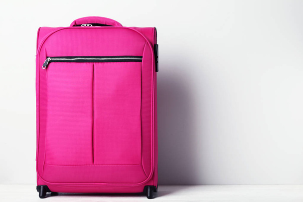 Pink suitcase on grey background - Fotoğraf, Görsel