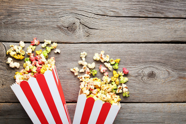 Colorful popcorn in paper bags on grey wooden table - Foto, Imagem