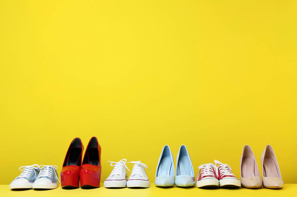 Different female shoes on yellow background - Photo, image