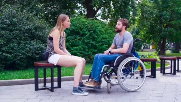 junger behinderter Mann sitzt mit seiner Frau im Park - Filmmaterial, Video