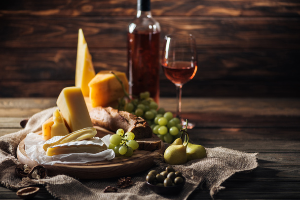 different types of cheeses, grapes and pears on rustic tablecloth - Photo, Image