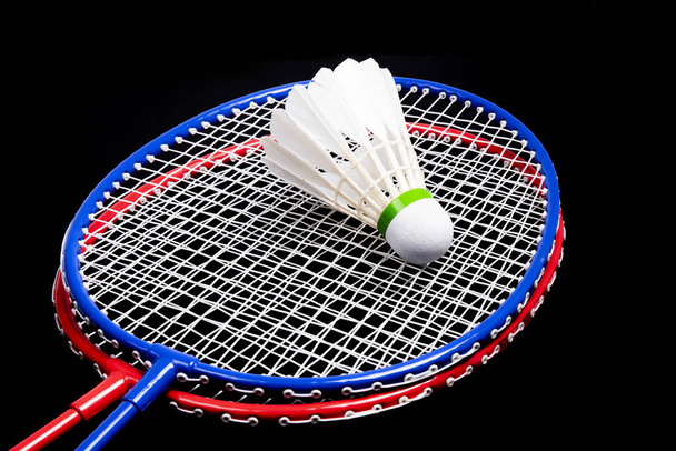 badminton raquete e shuttlecock em um fundo preto - Foto, Imagem