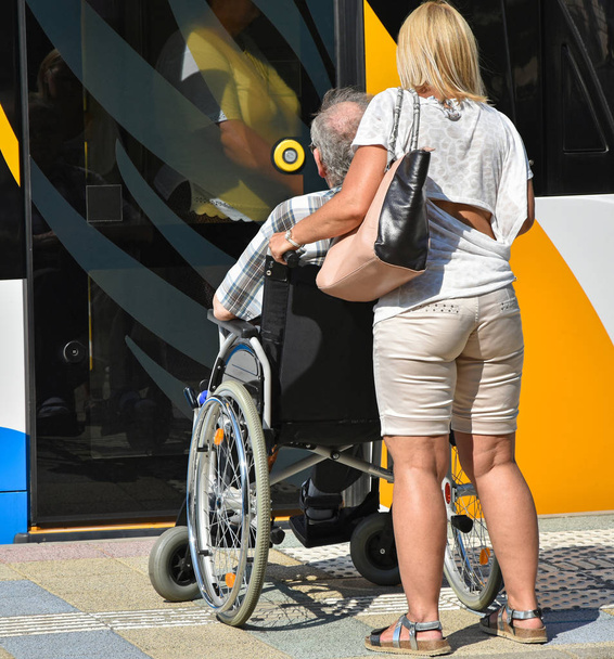 Alter Mann im Rollstuhl neben Straßenbahn - Foto, Bild
