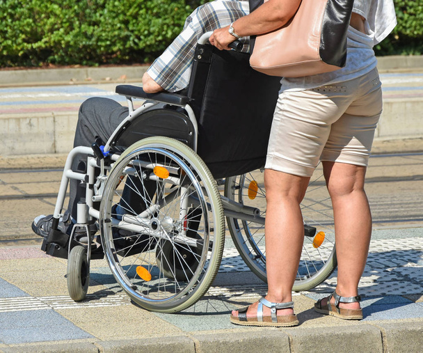 Старий в інвалідному візку і жінка
 - Фото, зображення