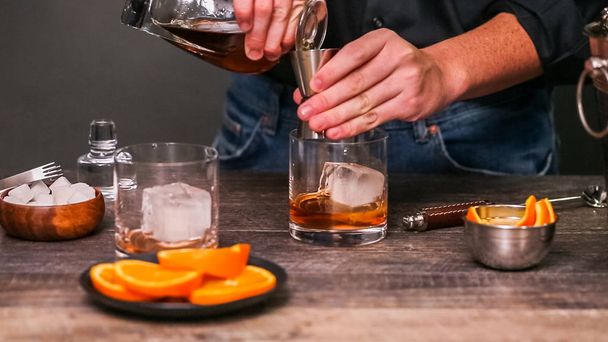 Bourbon παλιό απαρχαιωμένο κοκτέιλ γαρνιρισμένο με φλούδα πορτοκαλιού. - Φωτογραφία, εικόνα