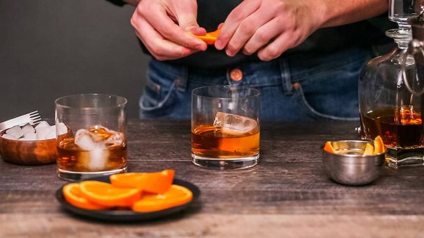 Bourbon cóctel a la antigua adornado con cáscara de naranja
. - Foto, imagen