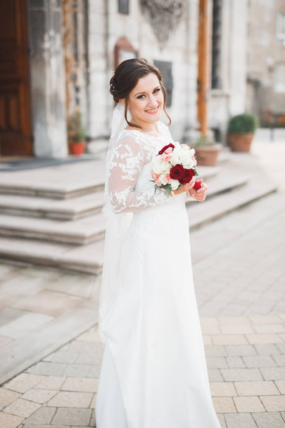 Portrait of stunning bride with long hair posing with great bouquet - Фото, изображение