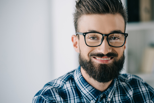 close-up portrait of bearded smiling man in eyeglasses looking at camera - Фото, изображение