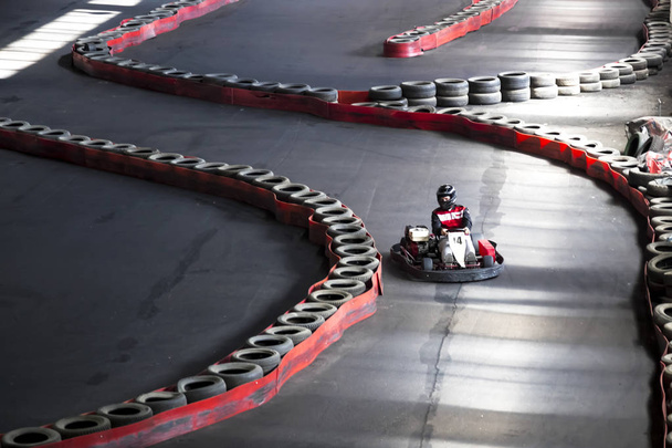 Riding on karting on the auto track. A young guy at the wheel of a carting. - Foto, imagen