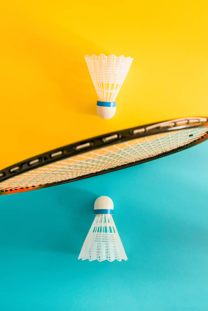 Volant ve sarı zemin üzerine badminton oynamak için raket. Yaz eğlence kavramı. Minimalizm Pop Art. - Fotoğraf, Görsel