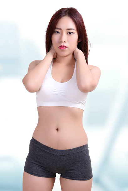 schöne asiatische Frau trägt Fitness-Kleidung in Fitness-Center - Foto, Bild