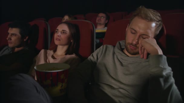 Man sleep at cinema movie. Guy sleeping at cinema date. People watch boring film - Footage, Video