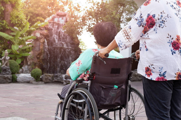 Hausmeister verbringt Zeit an der frischen Luft mit Patient im Rollstuhl. - Foto, Bild