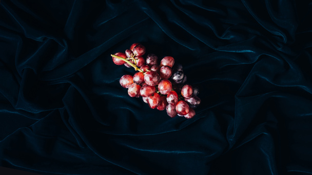 top view of fresh ripe red grapes on dark fabric - Фото, изображение