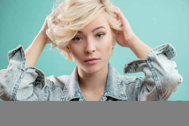 stylish awesome blond girl touching her hairstyle - 写真・画像