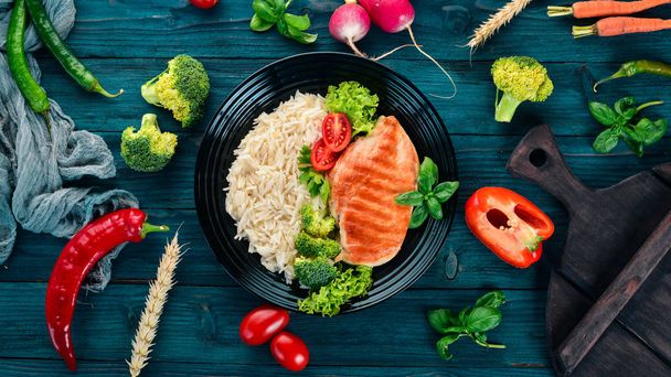 Chicken Breast Grill with Rice and Vegetables. Healthy food. On a blue wooden table. Top view. Free space for text. - Photo, Image