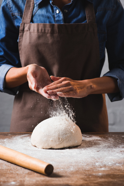 cropped shot of woman in apron kneading dough for pizza - Foto, immagini