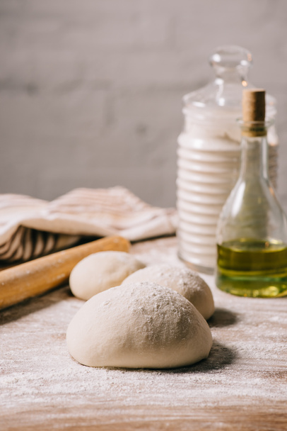 selective focus of raw dough for pizza and ingredients on tabletop - Photo, Image