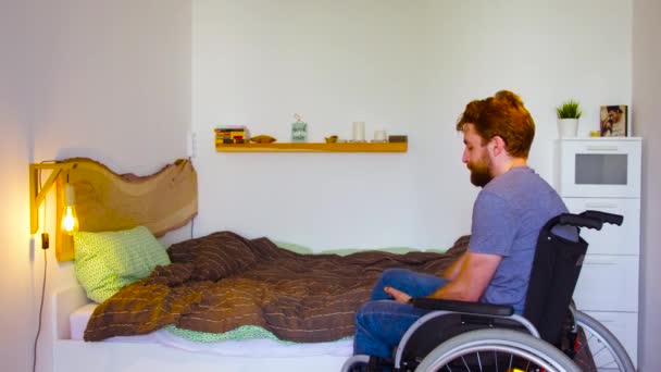 Behinderter Mann tauscht Rollstuhl gegen Bett - Filmmaterial, Video