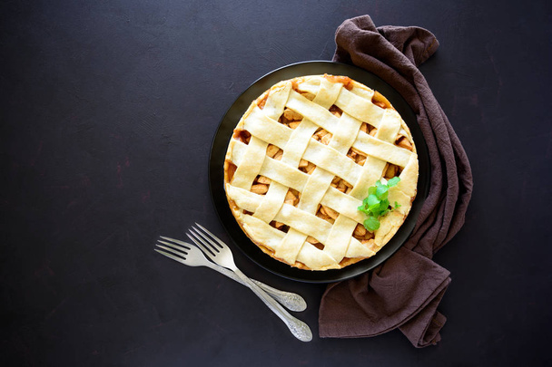 Fresh baked classic American apple pie on dark wooden background. Top view. Copy space - Fotó, kép