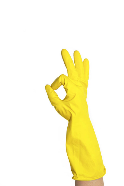 OK teken van gele rubberen handschoenen. Voorbereiding voor het reinigen. Handen schoon na het schoonmaken. Piepende mensen. Wassen van vloeren, afwas. Rubber handschoenen aan de hand. Rubber handschoenen aan een hand op een witte achtergrond. Rubber handschoenen voor het reinigen. - Foto, afbeelding