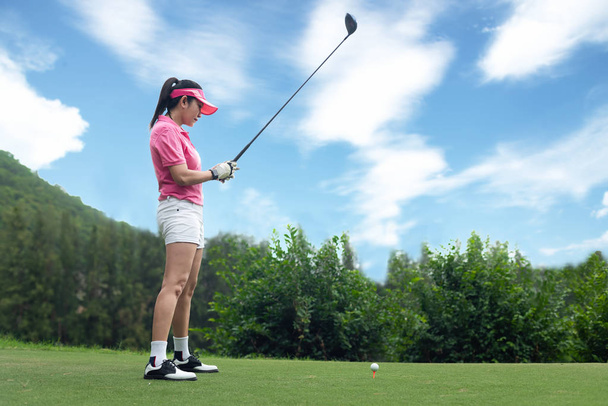 Asian kobieta golf gracz w golfa huśtawka tee off na wieczór zachód zielony czas, ona prawdopodobnie ćwiczenia. Zdrowe i Lifestyle Concept. - Zdjęcie, obraz