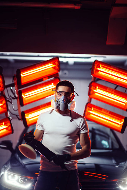 man wearing protective mask and glasses holding polishing machine - Фото, изображение