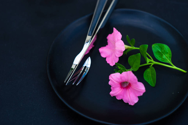 Apparecchiatura tavola rustica con petunia rosa fiori per la cena estiva su sfondo scuro con spazio copia
 - Foto, immagini