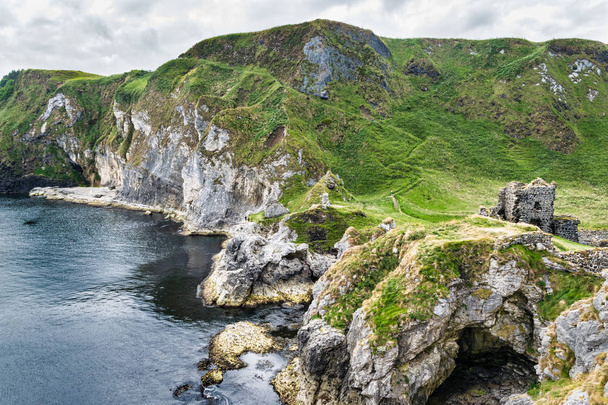 Ez az Kinbane kastély, a tengeri sziklák, amelyek kinyúlása be az Atlanti-óceán, közel a város Ballycastle Észak-Írországban, egy kis félszigeten épült. a kastély egy tenger alatti barlang. - Fotó, kép
