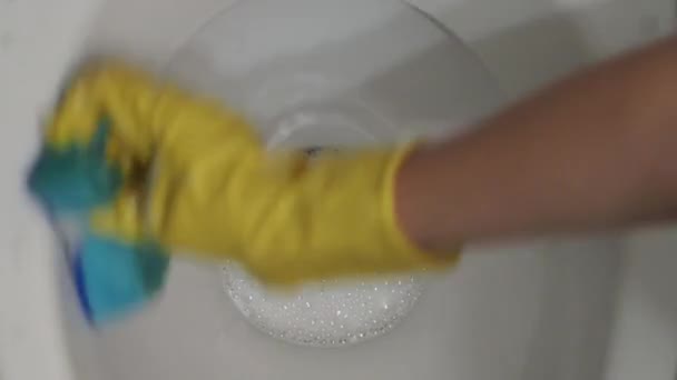 Kobieta myje z łyka wewnętrzną część muszli klozetowej. - Materiał filmowy, wideo