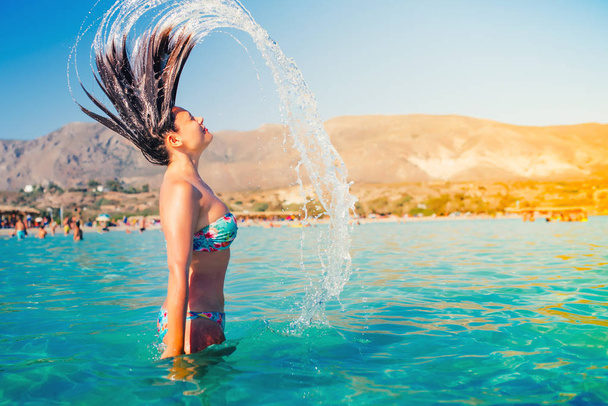 Beautiful portrait of sexy woman in bikini splashing water with hair in sea water. Summer portrait - Photo, image
