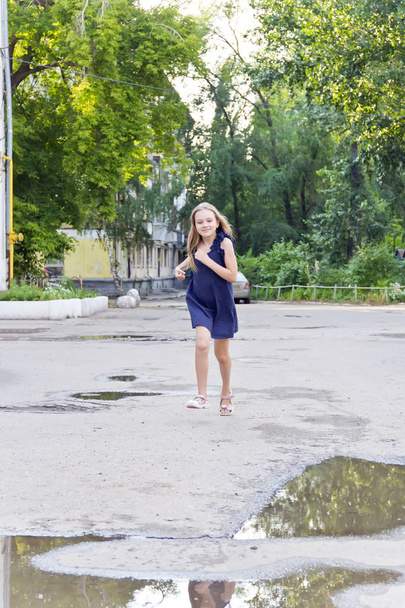 Cute running European girl with disheveled hair in green park - 写真・画像
