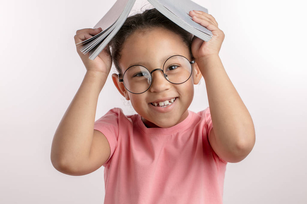 positive mulatto girl is having fun with a book - Photo, image