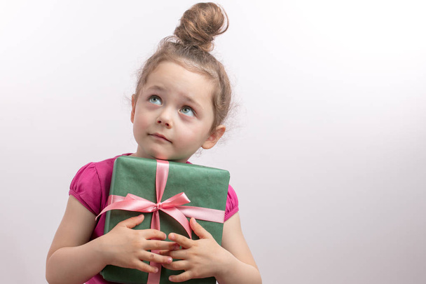 pretty girl with green eyes hugging gift box and looking up - Valokuva, kuva