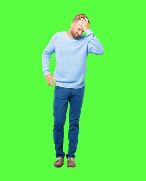 young blonde man posing on green background - Foto, imagen