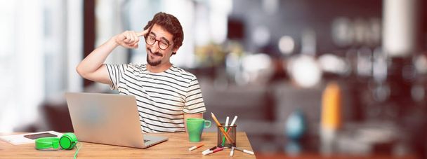 young bearded graphic designer with a laptop looking happy and surprised, smiling and thinking of an amazing new idea or solution, excited with epiphany and sudden inspiration. - Фото, зображення