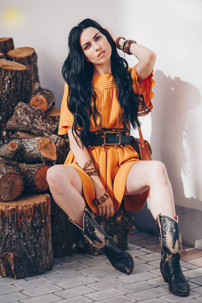Portrait of beautiful young brunette woman with makeup in orange dress - Zdjęcie, obraz