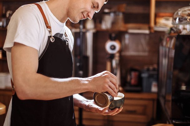 cheerful barista man preparing beverage from coffee at the cafe - Фото, зображення