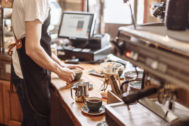 salesman is making espresso for clients - Фото, зображення