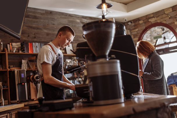 vendedor está haciendo café para la mujer
 - Foto, Imagen