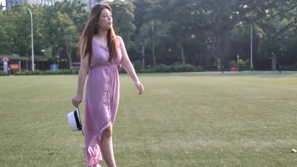 Asian chinese woman in slow motion walking on grass lawn - Metraje, vídeo