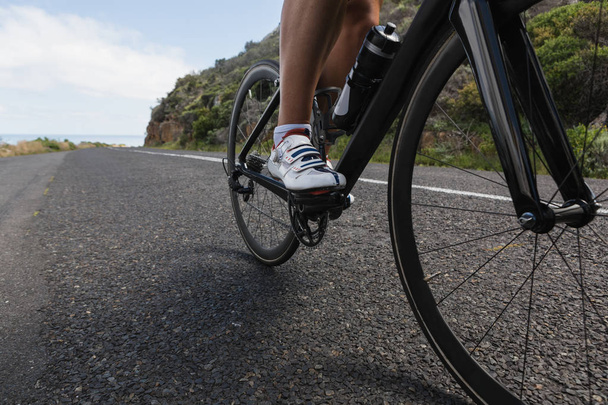 Pyöräilijä ratsastus maastopyörä tiellä aurinkoisena päivänä
 - Valokuva, kuva
