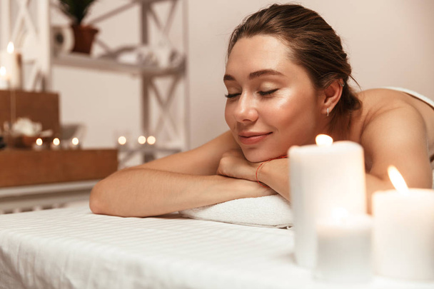 Obraz z niesamowite młoda kobieta piękne znajduje się w gabinecie masażu w spa nad świece. - Zdjęcie, obraz