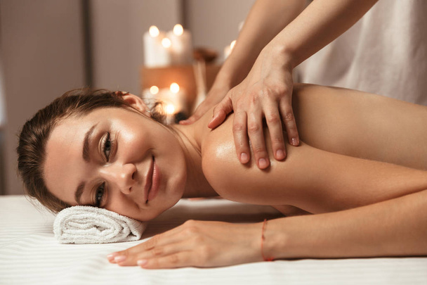 Delighted young woman having massage in the spa salon - Photo, Image