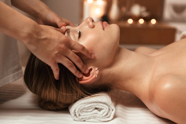 Beautiful young girl having face massage in spa salon - Фото, зображення