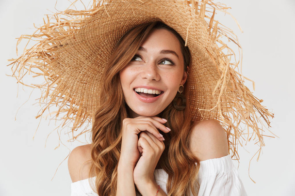Portrait closeup of adorable woman 20s wearing big straw hat posing on camera with lovely smile isolated over white background - Foto, Bild