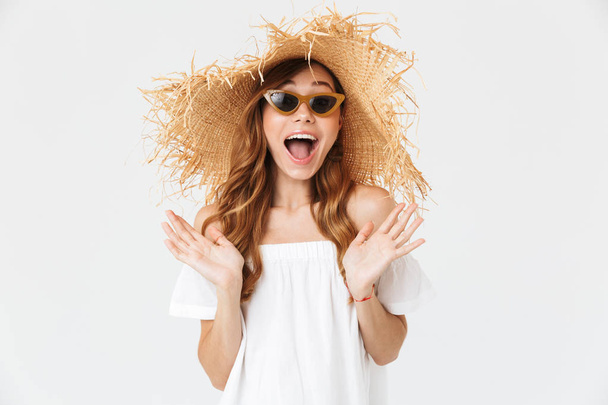 Portrait closeup of adorable woman 20s wearing big straw hat and sunglasses posing on camera with happy smile isolated over white background - Foto, afbeelding