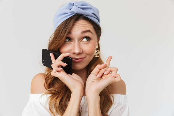 Photo of cheerful young woman 20s talking on mobile phone isolated over white background - Photo, Image