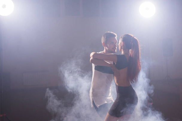 Active happy adults dancing bachata together in dance class - Foto, Bild