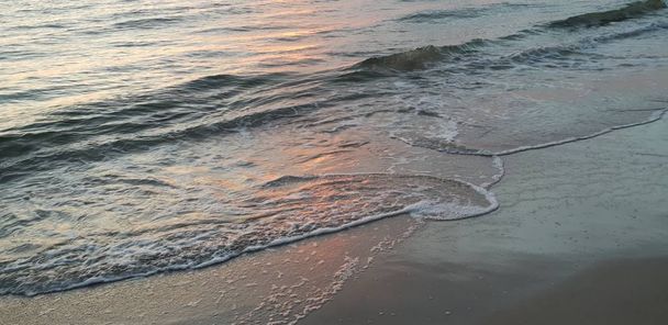 バルト海のビーチ、海辺、夏の夜に日没時に海岸線.  - 写真・画像